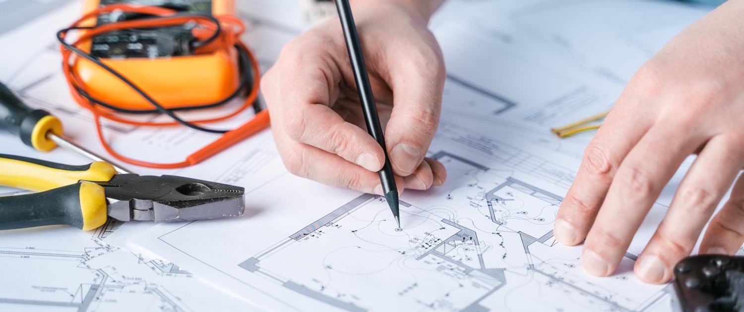 Close up view of electrical engineer drawing up plans