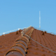 Tile roof with chimney and lightning protection system installed. Lightning rods. Close-up shot. Lightning conductor.