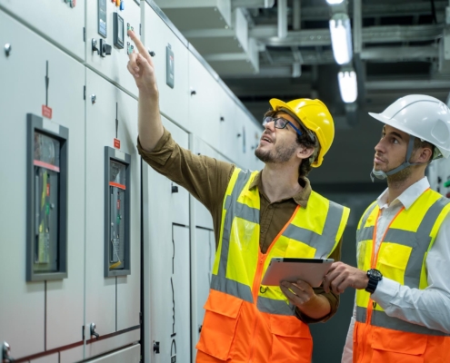 Two professionals inspecting electrical box