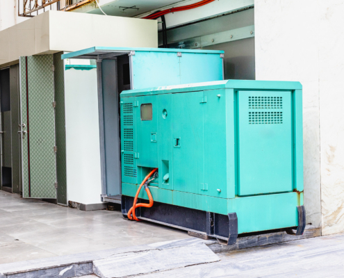 Large green industrial generator outside building